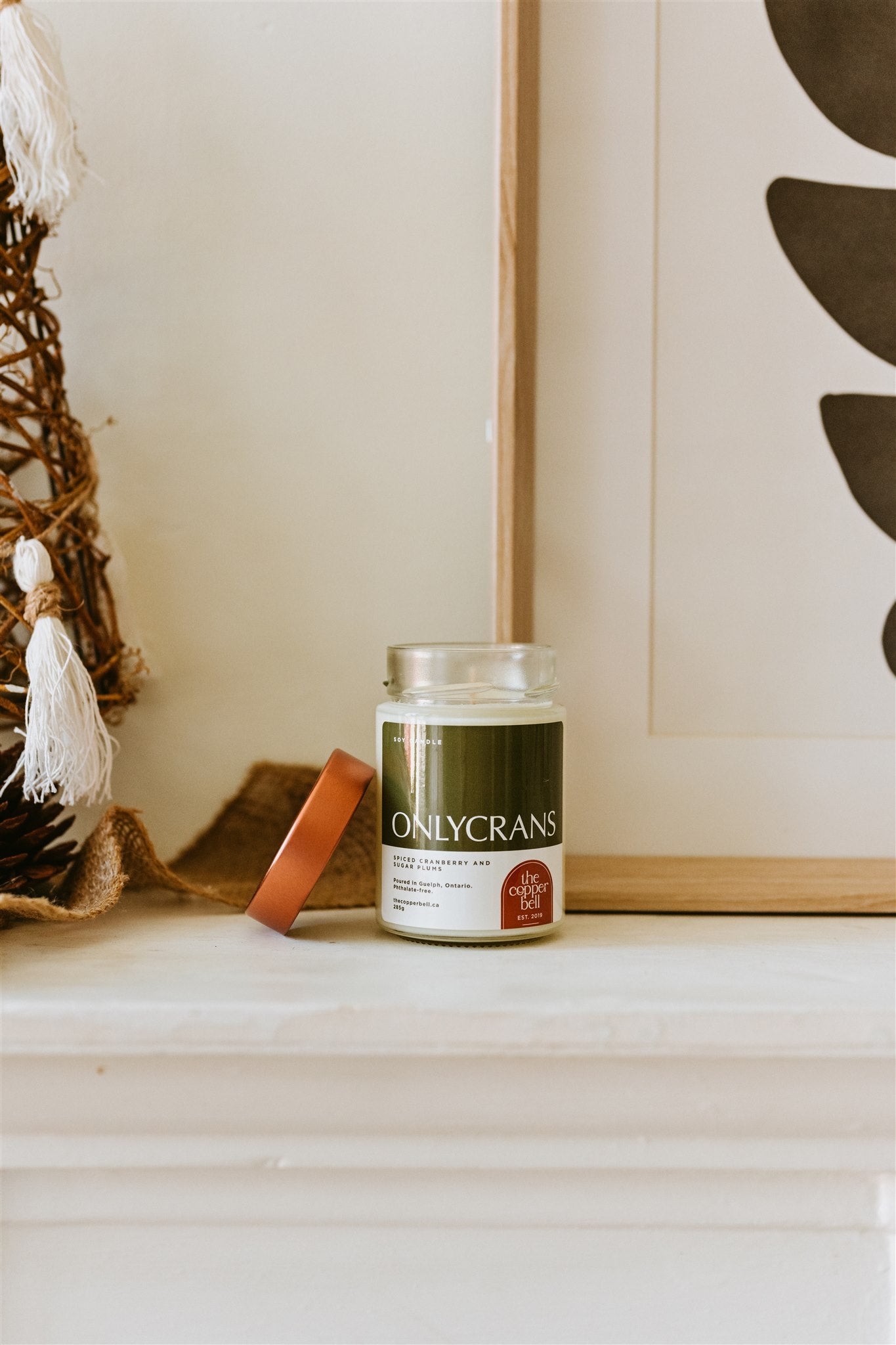 christmas scented candle on a white mantel.