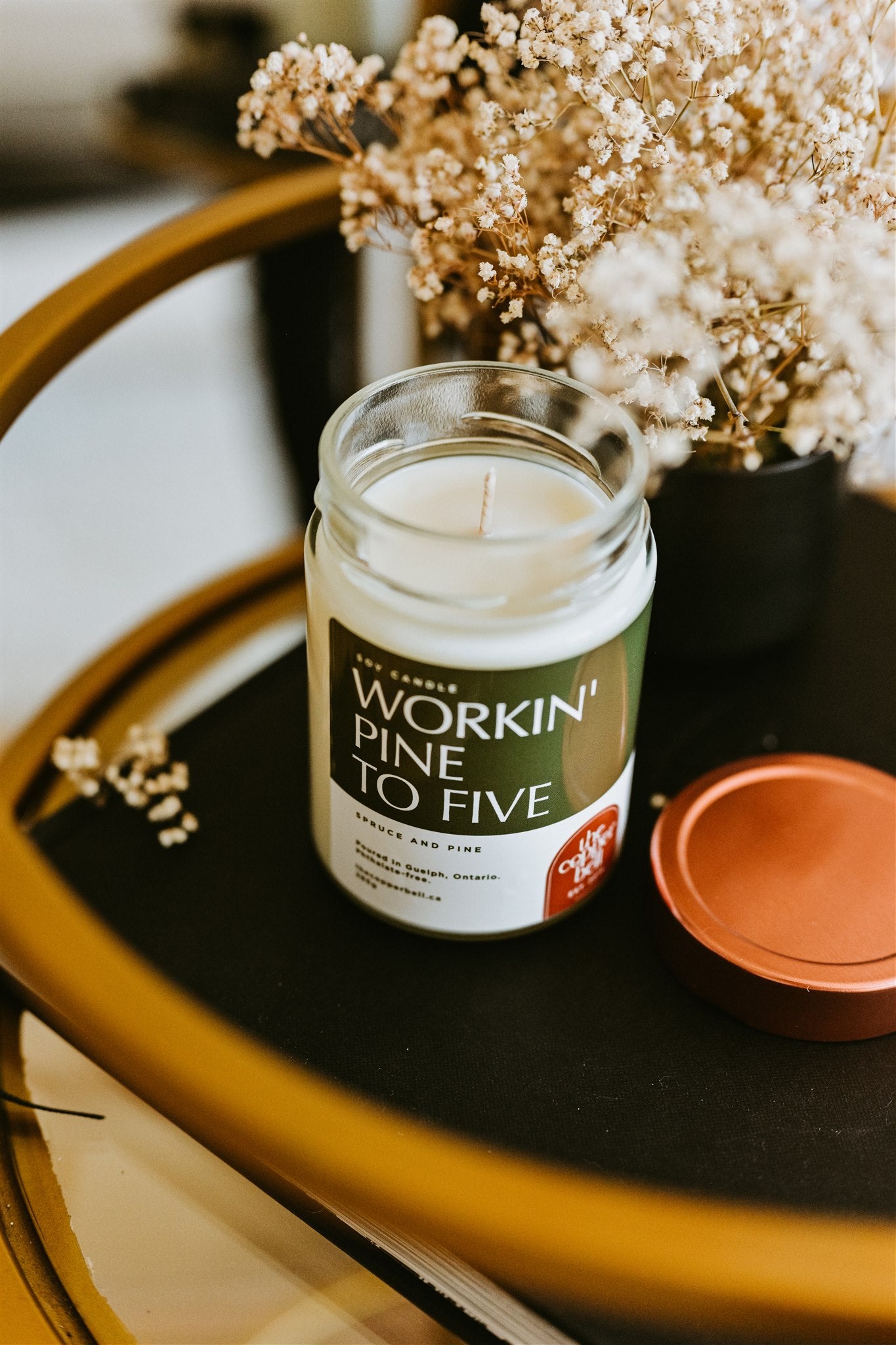 christmas tree scented candle displayed on a brass bar cart. the perfect christmas gift for those who like to keep a fake tree.